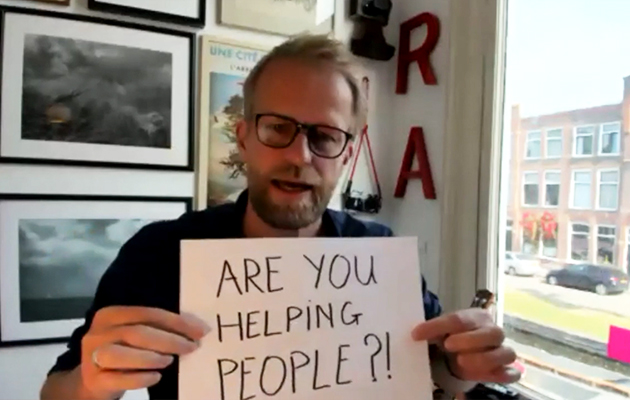 Man holding sign that says Are you helping people?