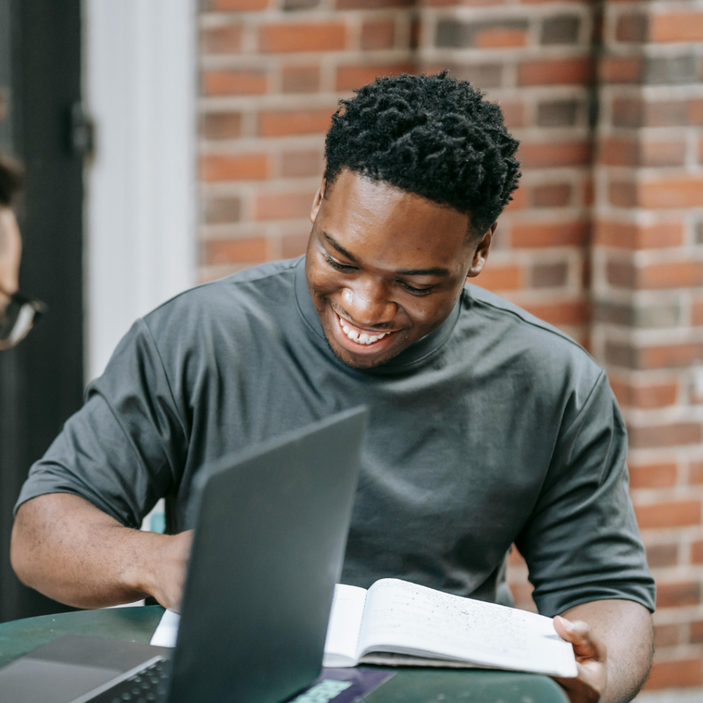 Man in front of book and laptop