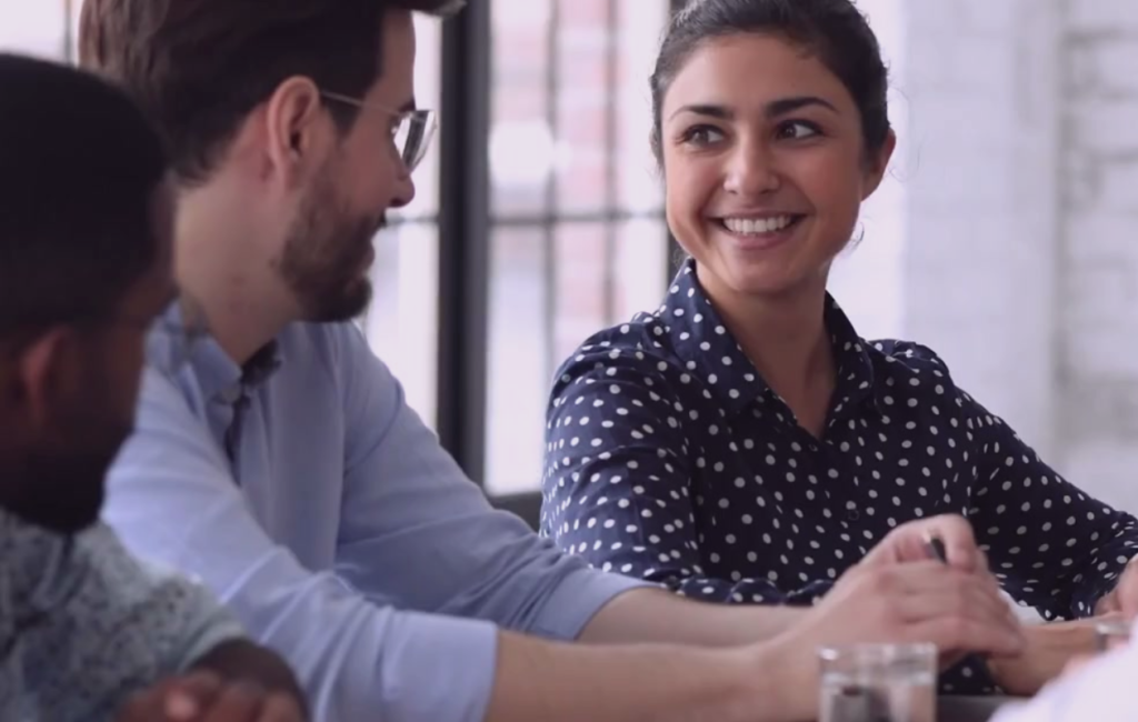 Three people smiling and having a discussion