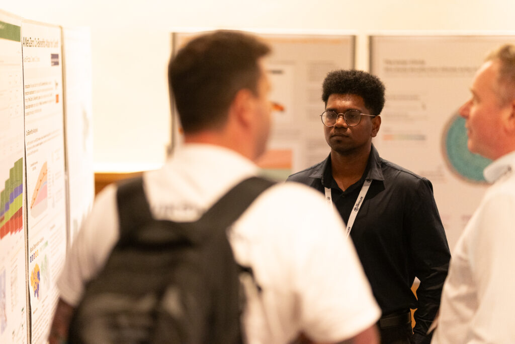 Attendees standing whilst networking in front of the data viz poster display at DataFest 2026